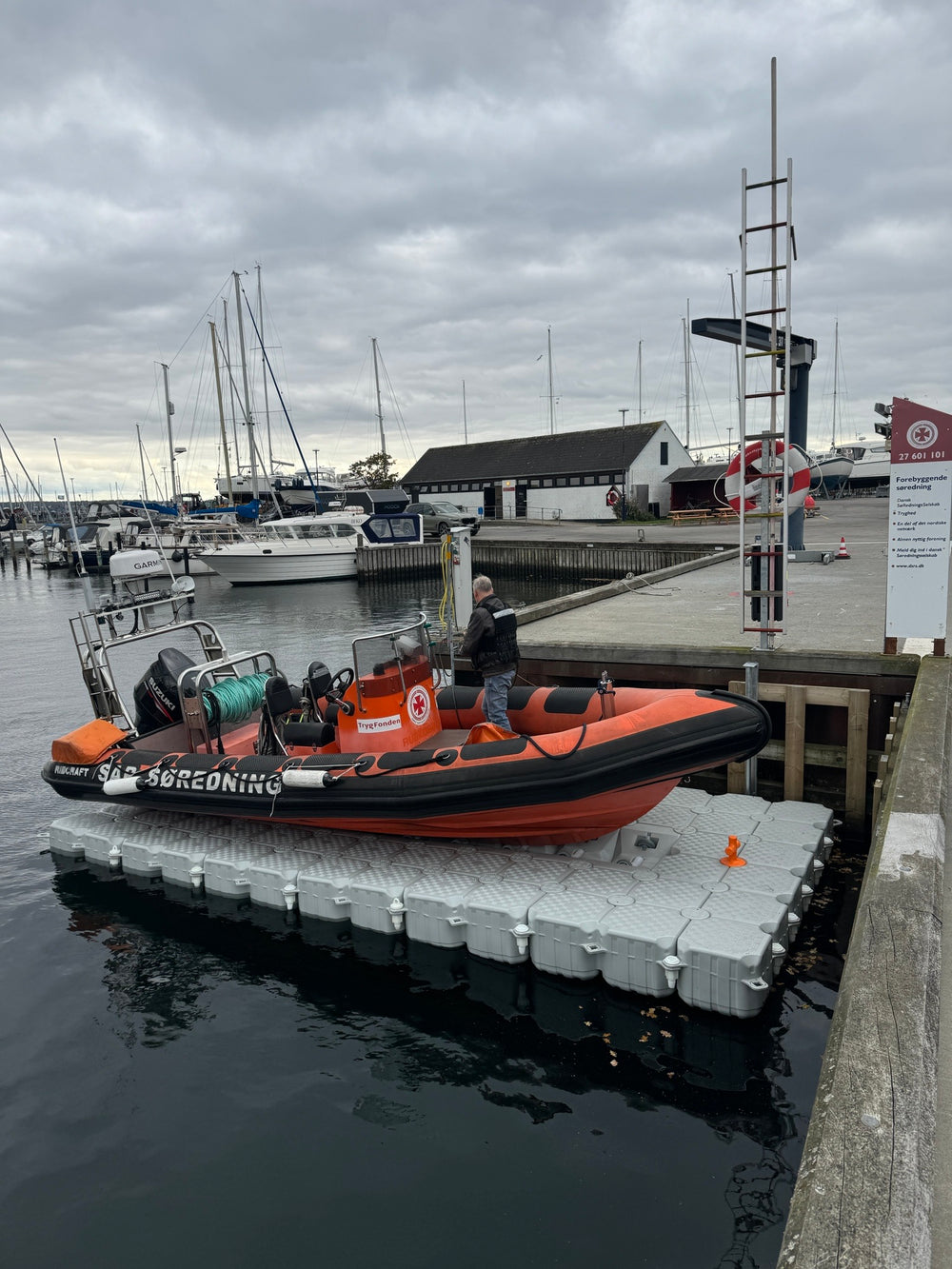 Premium motorbåd på en modulær flydedok i en nordisk marina ved solnedgang